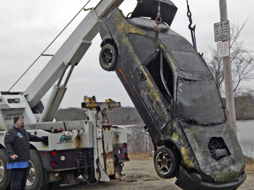 A stolen vehicle that was pulled out of Freeman Lake on Tuesday dangles from a wrecker used by Christopher’s Towing as Christopher Ferreira operates the truck. The car was spotted in the lake by a man who was using an underwater drone, according to police. 